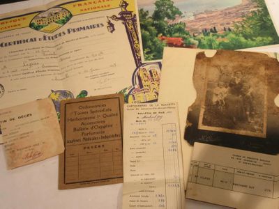 quelques vieux papiers sont posés sur une table, avec une photo d'un château en arrière-plan