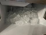a pile of ice cubes inside of a freezer