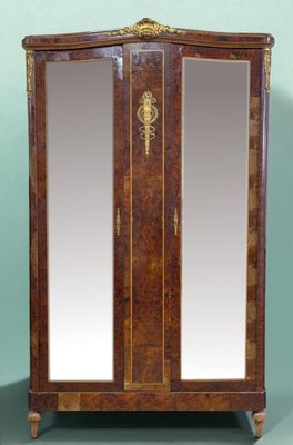 an antique wooden armoire with a mirror on top of it