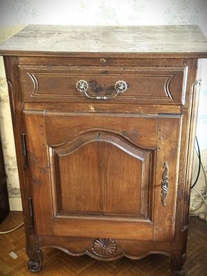 a wooden cabinet with a marble top on a hard wood floor