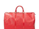 a red duffel bag sitting on top of a white surface