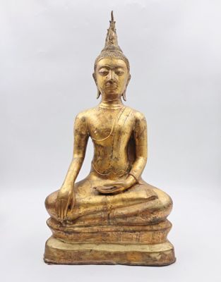 une statue de Bouddha en or assise au sommet d'une pile de livres