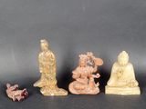 three small figurines of buddhas sitting on a black surface