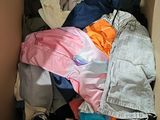 a cardboard box filled with clothes and a pair of shoes