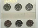 six pièces différentes dans une vitrine posée sur une surface blanche