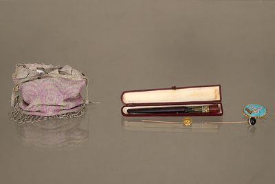 une petite boîte contenant un stylo et un petit sac muni d'un anneau