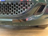 a close up of a car ' s front grill with holes in it