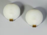 three white balls are sitting on top of each other on a white surface