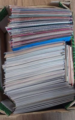 une boîte remplie de magazines posée par terre