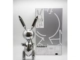 the silver rabbit is standing next to the box of the silver rabbit