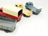 several toy trucks are lined up in a row on a white surface