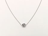 un collier blanc orné d'un cercle en argent, monté sur une chaîne en argent