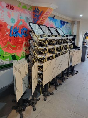 de nombreuses chaises alignées devant un mur couvert de graffitis