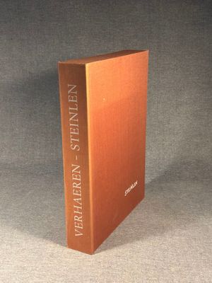 an orange book sitting on top of a table next to a black background