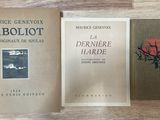 Trois livres sont posés sur une table au plateau en bois.