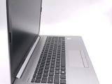 a silver laptop with a black keyboard on a white surface