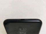 the back of a black cell phone sitting on top of a white table