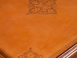 a brown table with a leather top on a grey background