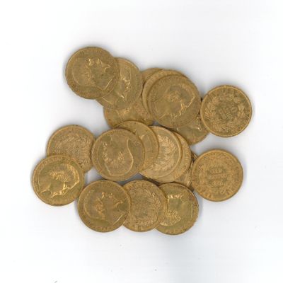 une pile de pièces d'or posée sur une surface blanche