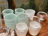 many cups and bowls on a table with a painting in the background