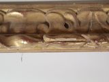 a close up of a gold frame on a white wall