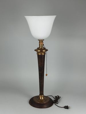 une lampe en laiton plaqué, dotée d'un abat-jour en verre blanc et posée sur un socle en bois