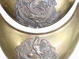 two metal bowls with designs on them on a white surface