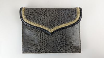 une image représentant un sac à main noir et doré sur fond blanc