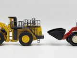 two toy tractors that are next to each other on a white surface