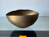un bol en or posé sur une table en verre