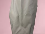 a grey bag sitting on top of a pink surface
