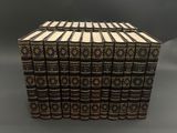 un coffret de douze livres aux reliures dorées sur fond gris