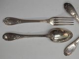 four spoons and a fork on a white table