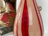 a red and white vase and a lamp on a table