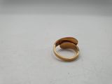 a close up of a gold ring on a white surface