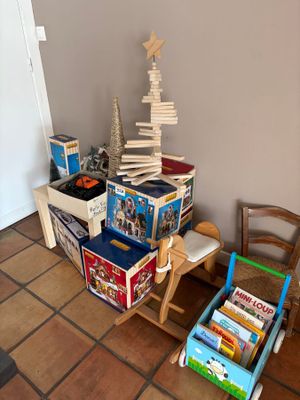 a pile of books sitting on a table next to a chair