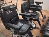 quatre fauteuils de coiffeur noirs dans une pièce où se trouve une échelle