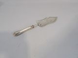 a silver spoon with a handle sitting on a white surface