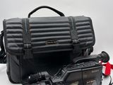 a black camera and a black bag on a white surface