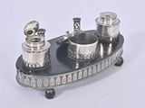 a silver plate with two silver cups and a spoon on it