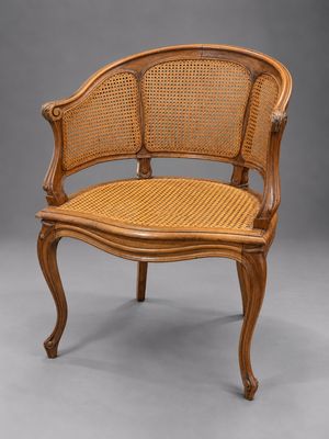 une chaise en bois avec une assise en osier sur fond gris