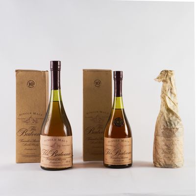 trois bouteilles de vin posées à côté d'une bouteille de vin sur une table