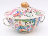 a bowl with a lid and a handle on a white surface
