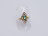 une image d'une bague en or avec une pierre verte au centre