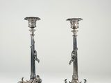 a pair of silver candlesticks with lion heads
