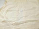 the top of a white shirt is laying on a white surface