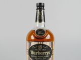 un gros plan sur une bouteille de bourbon posée sur une surface blanche