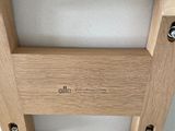 the back of a wooden chair with a white cushion on top of it