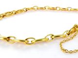 gros plan d'un bracelet en chaîne en or sur fond blanc