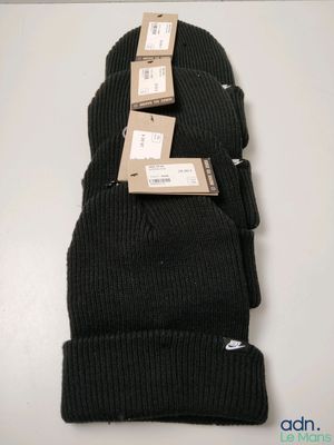 three black beanies stacked on top of each other on a table